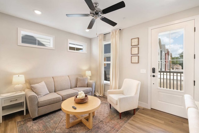 living room featuring wood-type flooring and ceiling fan