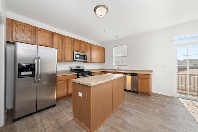 kitchen featuring light wood-type flooring, sink, a center island, and stainless steel appliances