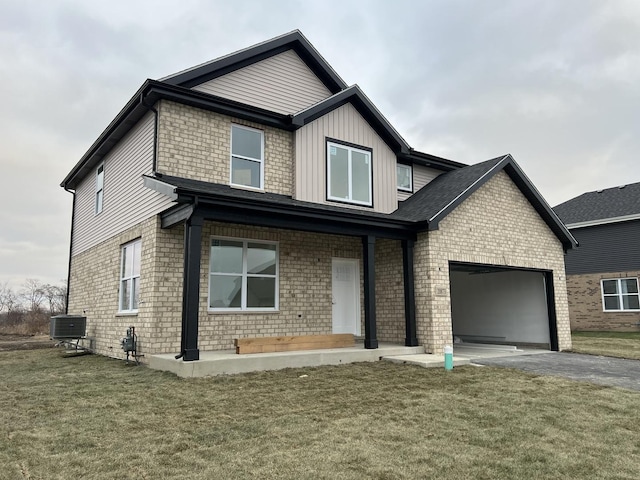 view of front of house featuring a garage, a front lawn, and central air condition unit