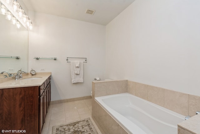 bathroom with vanity, tile patterned flooring, and tiled tub