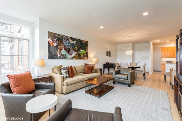 living room featuring light wood-type flooring and a chandelier