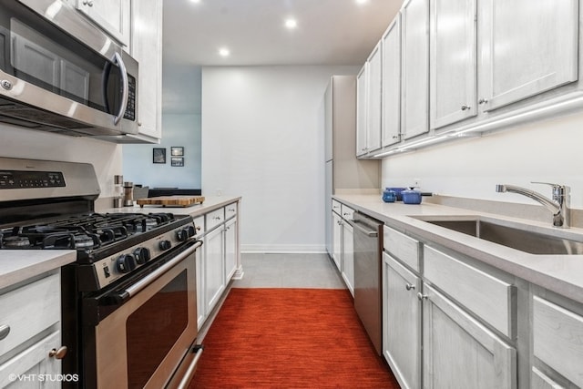 kitchen featuring stainless steel appliances, white cabinetry, and sink