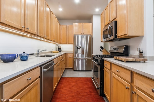 kitchen featuring dark tile patterned floors, sink, light brown cabinetry, and stainless steel appliances