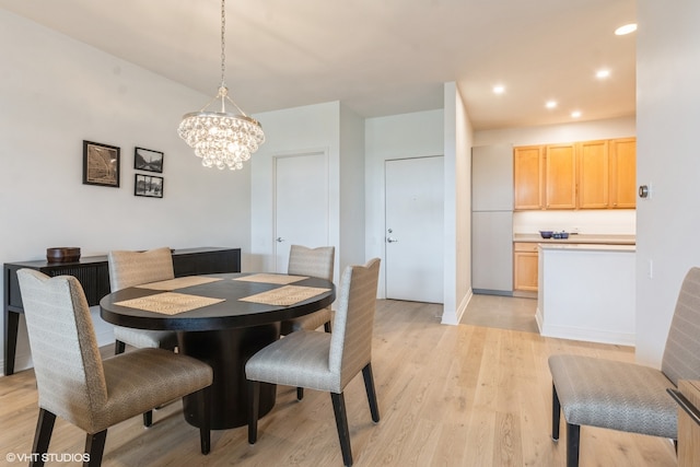 dining room with an inviting chandelier and light hardwood / wood-style flooring