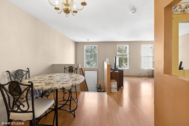 dining space featuring an inviting chandelier and light wood-type flooring