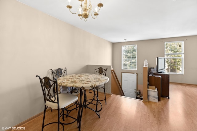 dining area featuring a healthy amount of sunlight, a chandelier, and light hardwood / wood-style floors