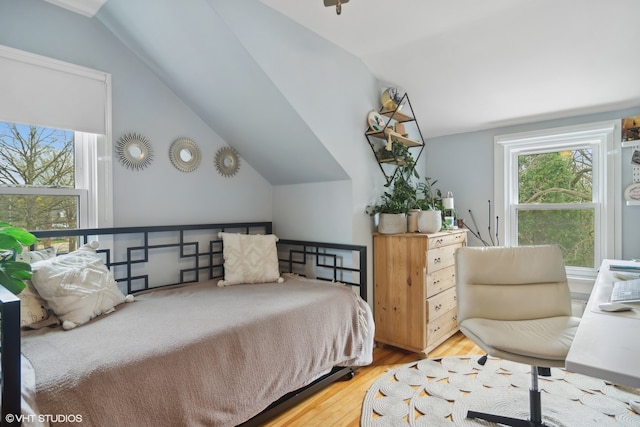 bedroom with lofted ceiling and hardwood / wood-style floors