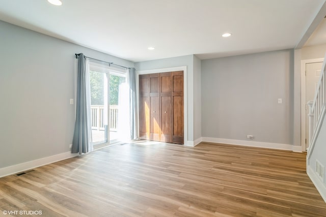 unfurnished bedroom featuring access to outside, a closet, and light hardwood / wood-style floors