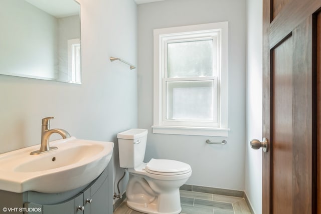 bathroom featuring plenty of natural light, vanity, and toilet