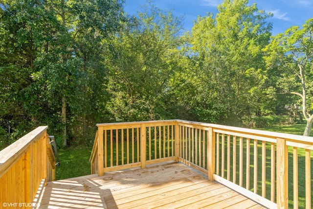 wooden deck featuring a lawn