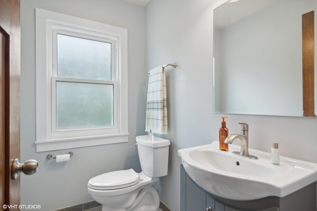 bathroom featuring plenty of natural light, toilet, and vanity