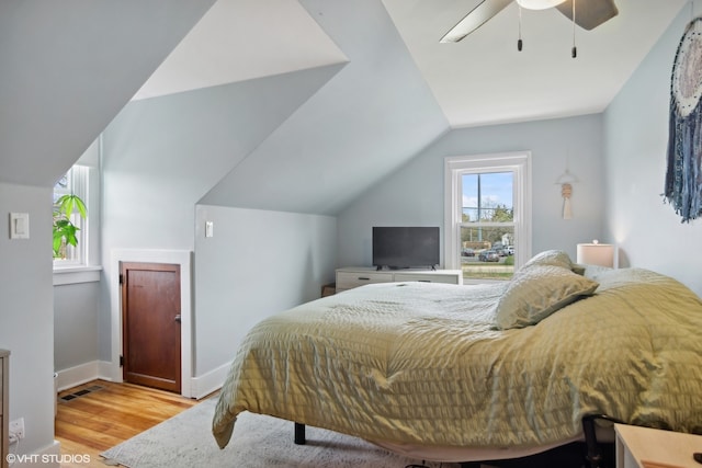 bedroom featuring ceiling fan, light wood-type flooring, and vaulted ceiling