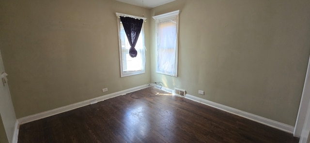 unfurnished room with dark hardwood / wood-style flooring