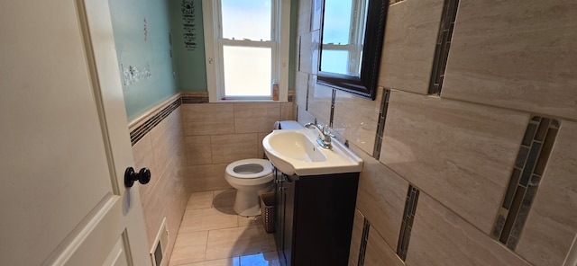 bathroom with tile walls, tile patterned floors, vanity, and toilet