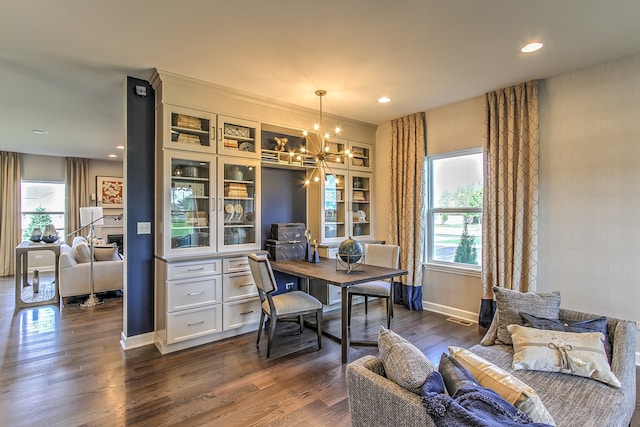 dining area featuring built in features, a chandelier, dark hardwood / wood-style flooring, and a wealth of natural light