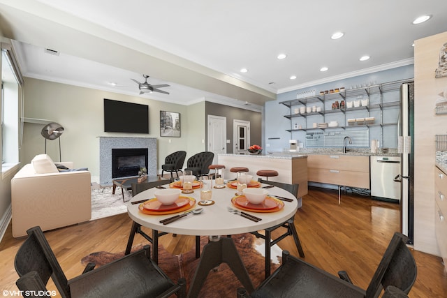 dining area with crown molding, ceiling fan, hardwood / wood-style floors, and indoor wet bar