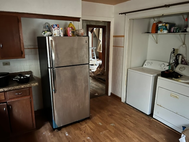 kitchen with stainless steel refrigerator, separate washer and dryer, and hardwood / wood-style flooring