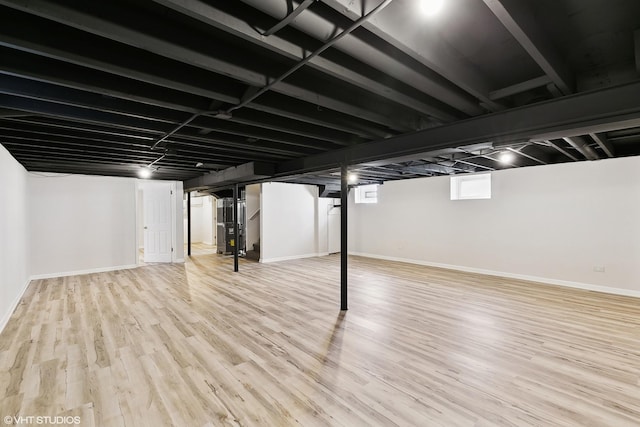 basement with heating unit and wood-type flooring