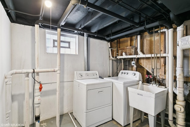 clothes washing area with washing machine and clothes dryer and sink