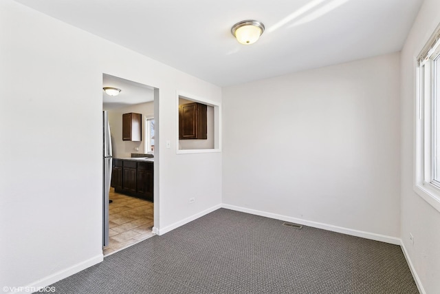 spare room featuring carpet flooring and a healthy amount of sunlight