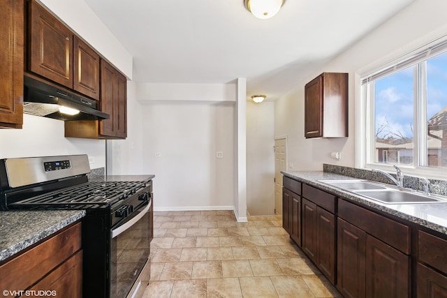 kitchen featuring gas stove, dark brown cabinetry, and sink