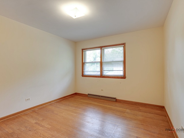 empty room with light hardwood / wood-style floors and a baseboard radiator