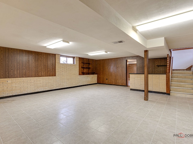 basement with wood walls and brick wall