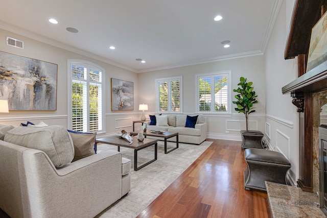 living room with wood-type flooring and ornamental molding