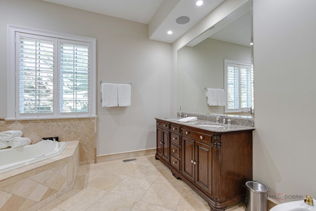 bathroom featuring tile patterned floors, a relaxing tiled tub, a wealth of natural light, and vanity