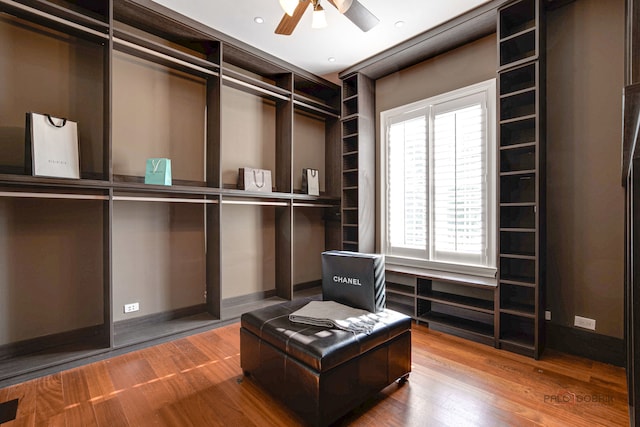 walk in closet featuring wood-type flooring and ceiling fan