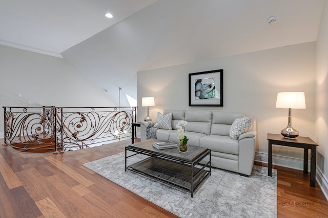 living room with crown molding, vaulted ceiling, and hardwood / wood-style flooring