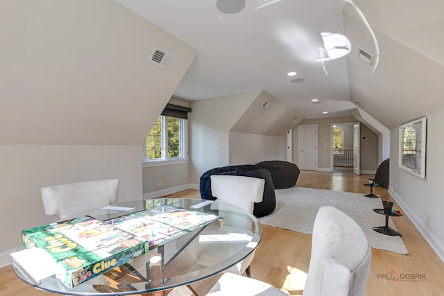 dining room with vaulted ceiling and light hardwood / wood-style floors