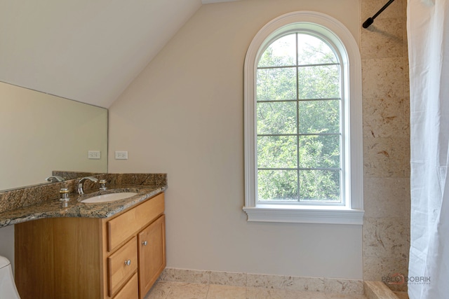 bathroom with a shower with curtain, vanity, lofted ceiling, and tile patterned floors