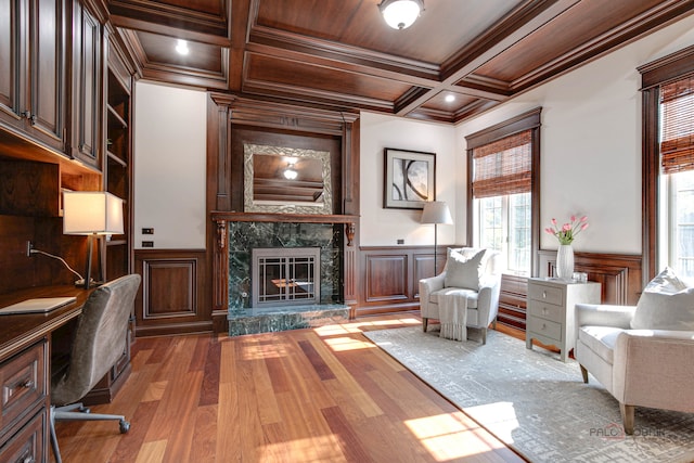 office featuring beam ceiling, a high end fireplace, wood-type flooring, coffered ceiling, and crown molding