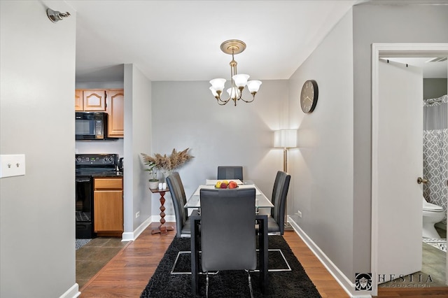 dining space with an inviting chandelier and dark hardwood / wood-style flooring