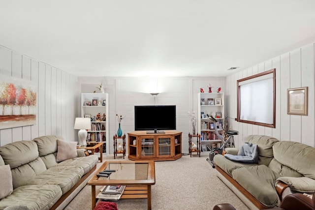 living room with carpet floors and wooden walls