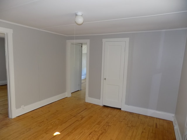 unfurnished room featuring crown molding and light hardwood / wood-style flooring