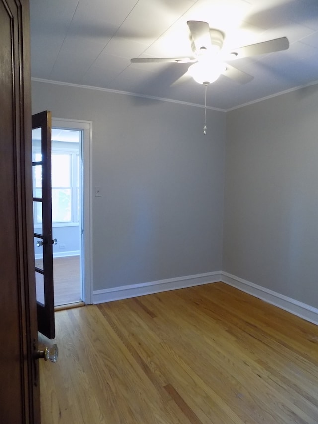 unfurnished room with ceiling fan, light hardwood / wood-style flooring, and ornamental molding