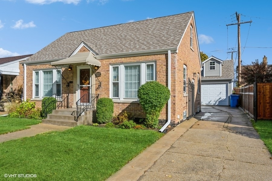 view of front of property with a front yard, a garage, and an outdoor structure