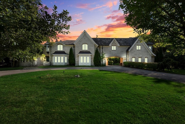 french provincial home with a lawn