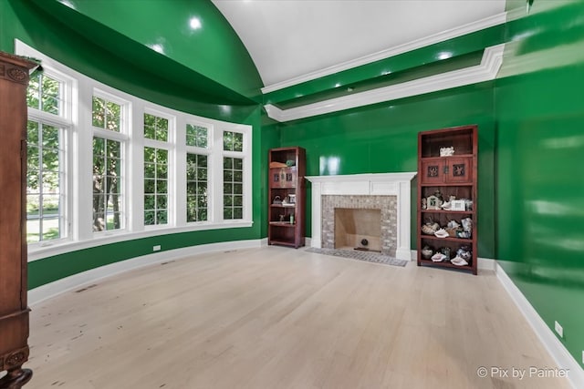 unfurnished living room with light hardwood / wood-style flooring, a tile fireplace, and a healthy amount of sunlight