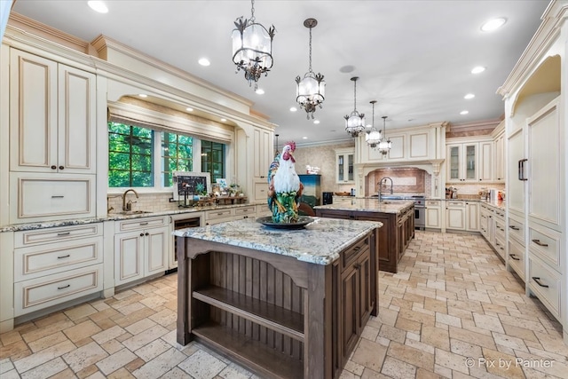 kitchen featuring pendant lighting, cream cabinets, a kitchen island with sink, and tasteful backsplash