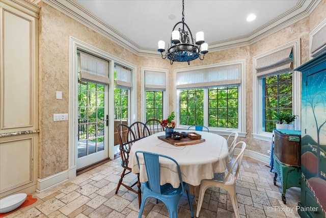 dining space with ornamental molding, a notable chandelier, and plenty of natural light