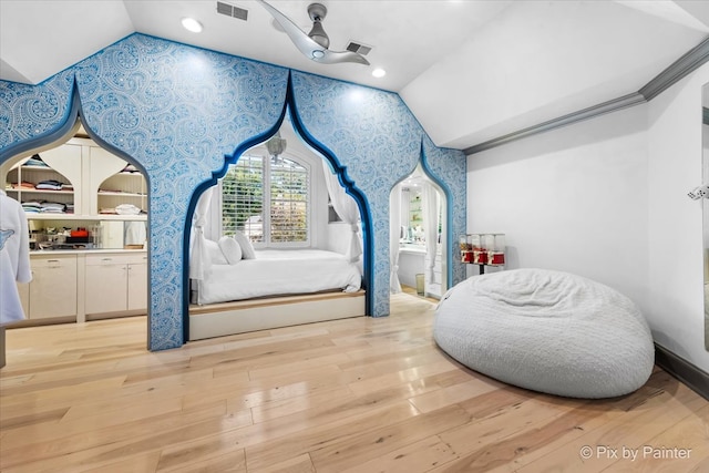 bedroom featuring light hardwood / wood-style floors, vaulted ceiling, and ceiling fan