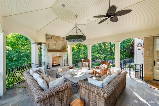 view of patio featuring an outdoor living space with a fireplace and ceiling fan