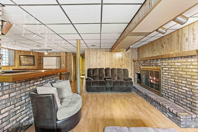 1632 Stanton Ave, Whiting, IN 46394 - living area featuring wood walls, wood finished floors, a brick fireplace, and a drop ceiling