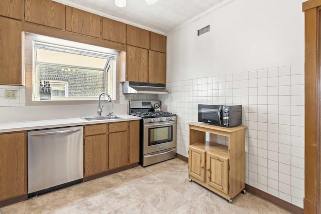 1632 Stanton Ave, Whiting, IN 46394 - kitchen featuring a sink, under cabinet range hood, light countertops, ornamental molding, and appliances with stainless steel finishes