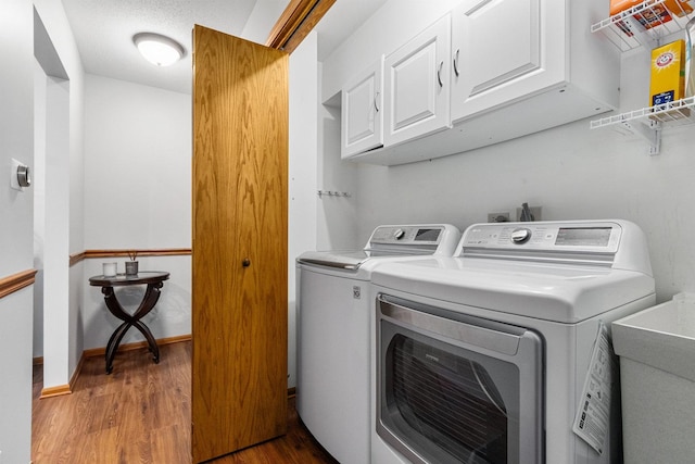 washroom featuring light hardwood / wood-style flooring, sink, washer and clothes dryer, and cabinets