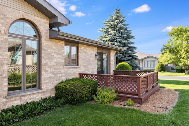 view of side of home featuring a wooden deck and a lawn