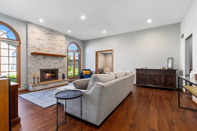 living room featuring dark hardwood / wood-style flooring and a brick fireplace